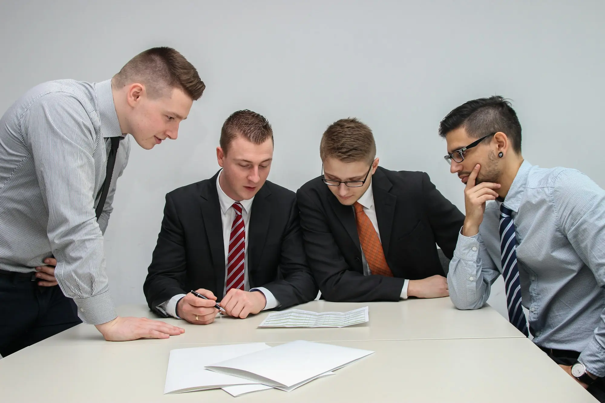 Four colleagues reviewing papers on a meeting table
